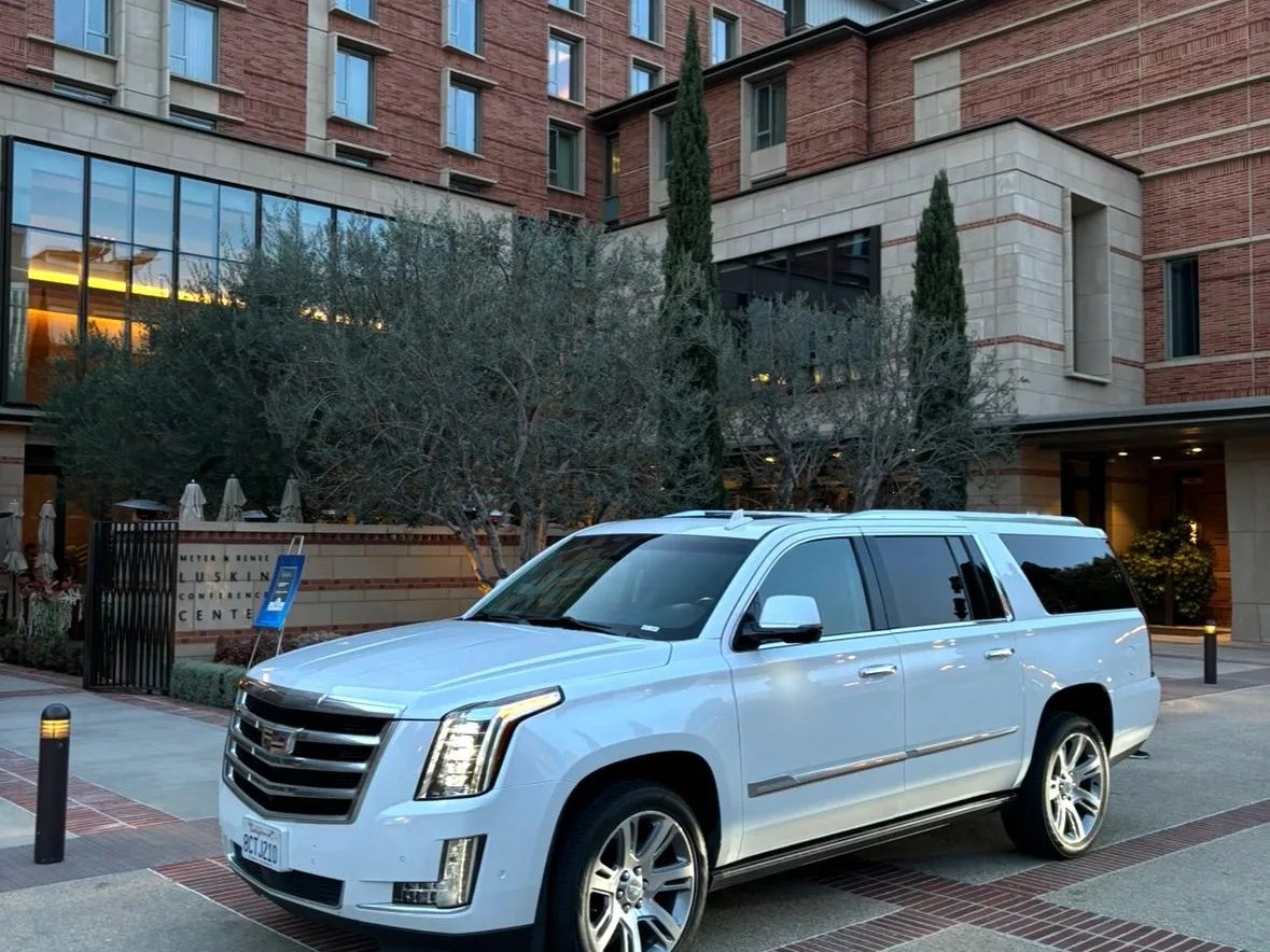 White luxury SUV parked at the Meyer and Renee Luskin Conference Center at UCLA at dusk